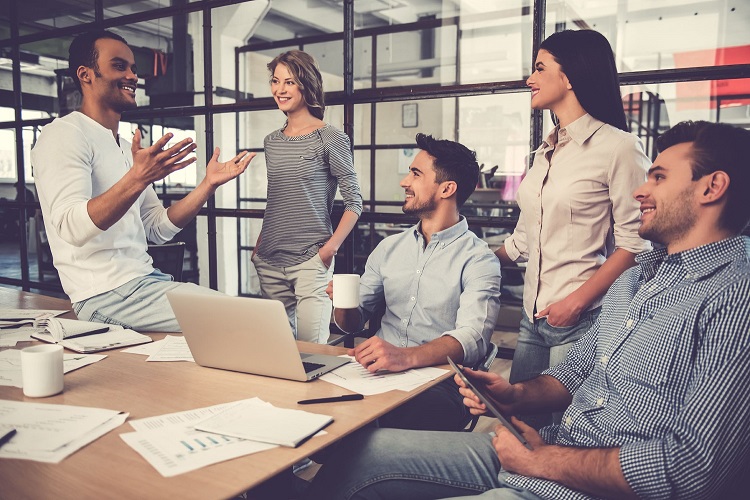 beautiful business people are using gadgets, talking and smiling during a conference in their office