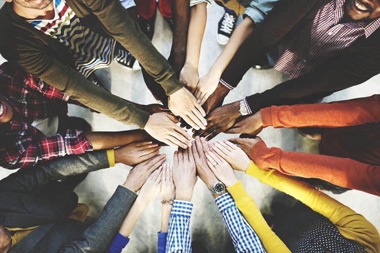 an aerial view of a group of people outstretching their hands toward each other