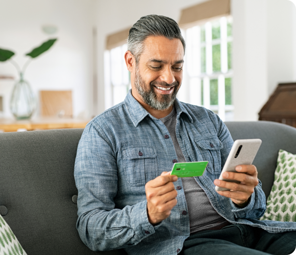 man reviewing credit report on smart phone on sofa