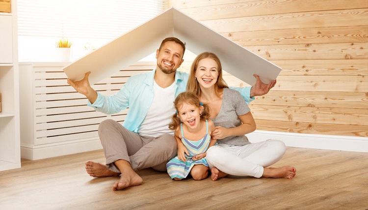 a smiling family holding a roof over their head