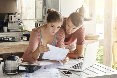 a couple reviewing their finances in their kitchen