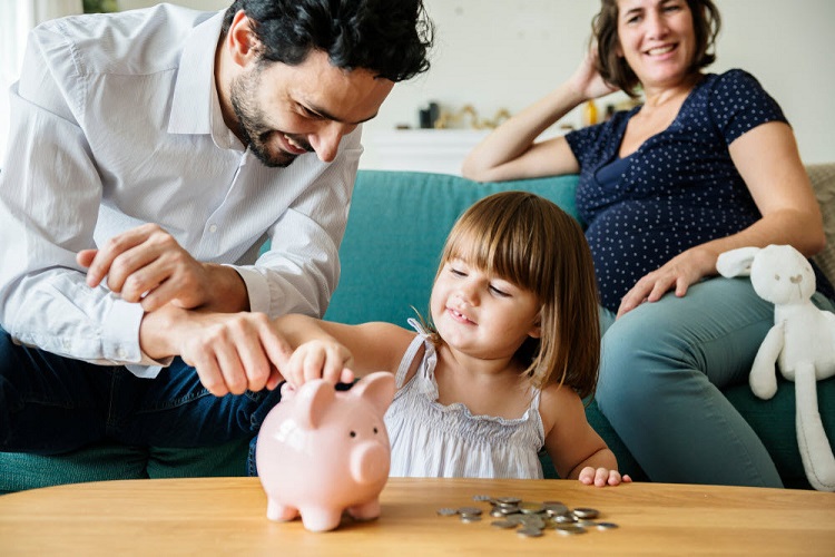 a mother and father help their child store change in their piggy bank